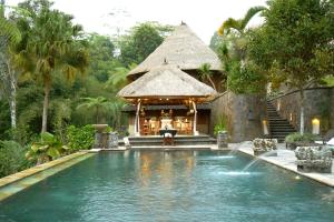 a swimming pool in front of a house with a building at Bagus Jati Health & Wellbeing Retreat in Tegalalang