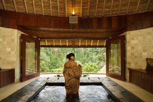 a woman standing in a pool of water in a room at Bagus Jati Health & Wellbeing Retreat in Tegalalang