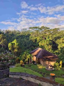 a house in a garden with trees in the background at Bagus Jati Health & Wellbeing Retreat in Tegalalang