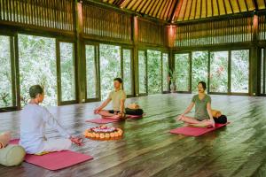 a group of people sitting on the floor in a yoga class at Bagus Jati Health & Wellbeing Retreat in Tegalalang
