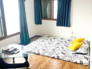 堺市にあるRent a leaping floor villa 2 mins to stationのガラステーブル付きの部屋のベッド1台 +13枚の写真