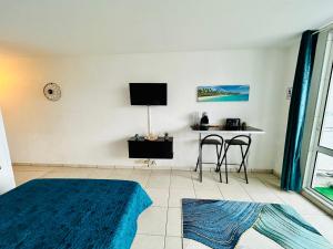 a room with a bed and a table and chairs at Studio Le Rivage - Accès plage in Le Gosier
