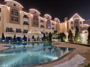 a large building with a swimming pool at night at Legend Valley Hotel Ha Nam in Phủ Lý