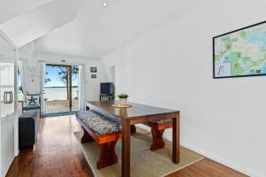 Un comedor con mesa y vista al mar. en Jado on the Lake, Jervis Bay, en St Georges Basin
