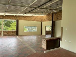 a large empty room with a brick wall and a table at Finca La Esperanza in Nobsa