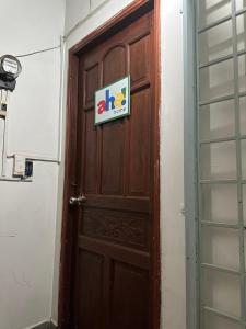 eine Holztür mit einem Schild darauf in der Unterkunft CoCo home 15 in Ho-Chi-Minh-Stadt