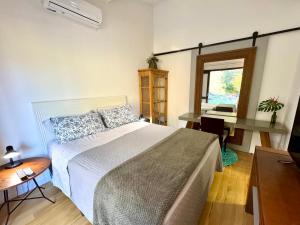 a bedroom with a bed and a desk and a window at Casa Ideal para Férias em Florianópolis in Florianópolis +38 photos