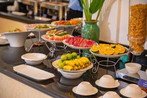 a buffet with many plates of fruit on a table at Athenia Hoi An Boutique Hotel & Spa in Hoi An