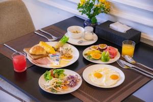 a table with four plates of breakfast food on it at Athenia Hoi An Boutique Hotel & Spa in Hoi An