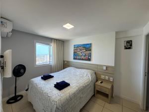 a bedroom with a bed with two blue towels on it at Incrível Vista VIP de Ponta Negra - Morro do Careca do 32º andar in Natal +57 photos