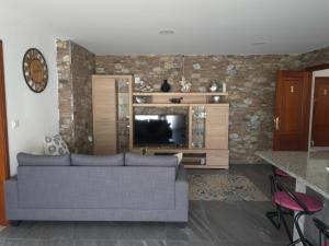 a living room with a couch and a tv at Casa Cadabón in Pontevedra