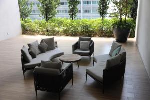 a patio with couches and chairs and a table at Luxury Apt close to KLCC Aria in Kuala Lumpur