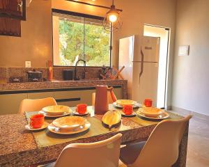 a kitchen with a table with plates of food on it at Chalé Baru - Ar-cond - Varanda Pôr do Sol - Cavalcante Goiás in Cavalcante