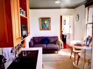a living room with a purple couch and a table at Loft on Blyth in Clyde