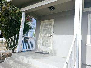 a white house with a white door and stairs at Cozy Craftman Cottage in Quiet Historic Vallejo Neighborhood in Vallejo