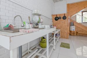 a white kitchen with a counter and a sink at RedDoorz Syariah at Eco Pesantren Daarut Tauhid in Cihanjuang 1