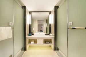 een badkamer met een wastafel en een spiegel bij Echarm Hotel Wuzhou Canghai Lake High Speed Railway Station in Wuzhou +17 foto's