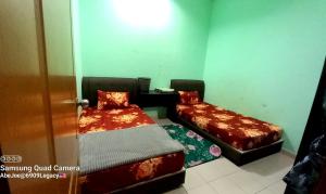 a small room with two beds and a chair at Homestay Kuala Berang Solehah Full Aircond Wifi & Netflix in Kuala Berang