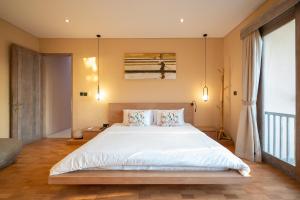 a bedroom with a large bed with white sheets and pillows at Villa Biku in Umalas