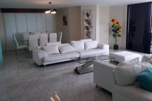 a living room with white couches and a table at Apartamento en malecón de Salinas hermosa vista in Salinas +137 photos