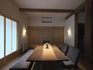 a room with a large wooden table and a couch at Akashi in Hakodate