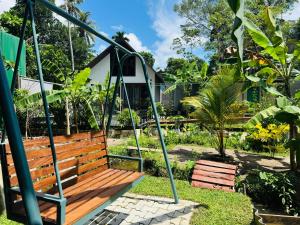 a wooden swing in a garden at Calm Side Villa Hikkaduwa in Hikkaduwa