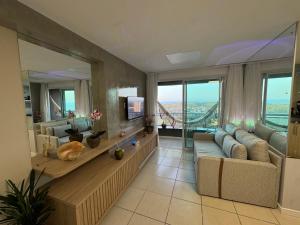 a large living room with a couch and a tv at Incrível Vista VIP de Ponta Negra - Morro do Careca do 32º andar in Natal