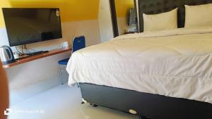 ein Schlafzimmer mit einem Bett und einem Flachbildfernseher in der Unterkunft Hotel Transit 1 in Jambu + 22 Fotos