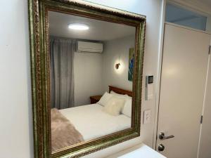 a mirror reflection of a bed in a bedroom at Mount Hub in Mount Maunganui