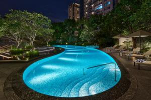 a large blue swimming pool in a city at night at InterContinental Taichung by IHG in Taichung