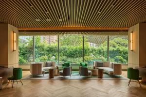 a lobby with couches and chairs and a large window at InterContinental Taichung by IHG in Taichung