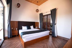 a bedroom with a bed and a large window at Bảo Lộc Home in Bảo Lộc