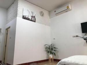 Ban Nong Song Phi Nongเกษมสุขรีสอร์ท Kasamesuk Resort的一间卧室，墙上挂着一盆白植物