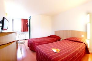 ein Hotelzimmer mit 2 Betten und einem TV in der Unterkunft Première Classe Rouen Nord - Bois Guillaume in Bois-Guillaume
