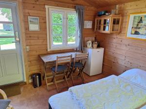 eine Küche mit Tisch und Stühlen und einem Kühlschrank in der Unterkunft Lyngholt Familiecamping in Allinge