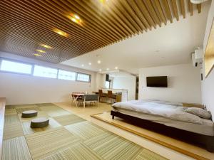 Un dormitorio con una cama y un comedor. en 島の宿 Amanzaーアマンツァー, en Ishigaki Island