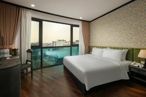 a bedroom with a large white bed and a window at Hanoi Plaza Suite Hotel & Spa in Hanoi
