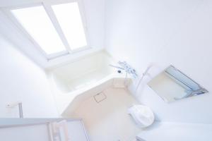 ein weißes Badezimmer mit Badewanne und Toilette in der Unterkunft CLASSE CINQ in Sapporo