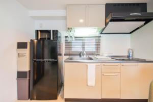eine Küche mit Kühlschrank und Spüle in der Unterkunft CLASSE CINQ in Sapporo