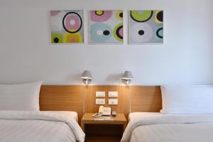 a hotel room with two beds and a phone on a table at HOTEL HI - Xinmin in Chiayi City +38 photos