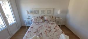 Un dormitorio con una cama con una colcha floral. en APARTAMENTOs IGLESIA DE SANTIAGO, en Jerez de la Frontera
