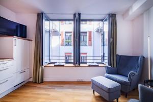 a living room with a chair and a large window at Altstadtwohnung "Klein Venedig" in Freiburg im Breisgau