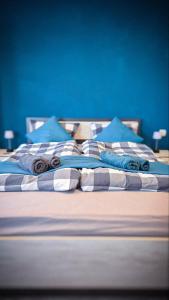 a bed with blue walls and blue pillows on it at Lavender Lodge Tsarichino in Tsarichino