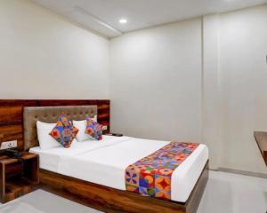 a bedroom with a bed with white walls at Hotel Golden Sands Inn Aslpha in Mumbai