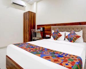 a bedroom with a bed with a colorful comforter at Hotel Golden Sands Inn Aslpha in Mumbai