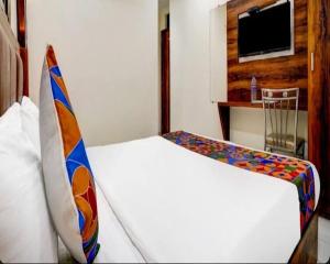 a hotel room with two beds and a tv at Hotel Golden Sands Inn Aslpha in Mumbai