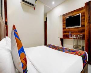 a bedroom with a bed and a tv on a wall at Hotel Golden Sands Inn Aslpha in Mumbai +37 photos