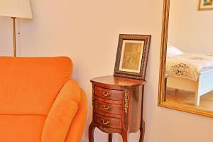 an orange chair and a mirror next to a dresser at Art Boutique Residence - City Center - Calea Victoriei in Bucharest +86 photos