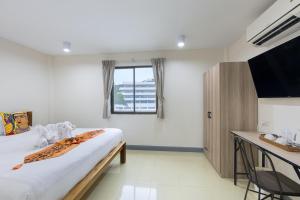 a hotel room with a bed and a television at PMS Boutique Patong in Patong Beach