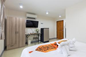 a bedroom with a bed with a television and a desk at PMS Boutique Patong in Patong Beach